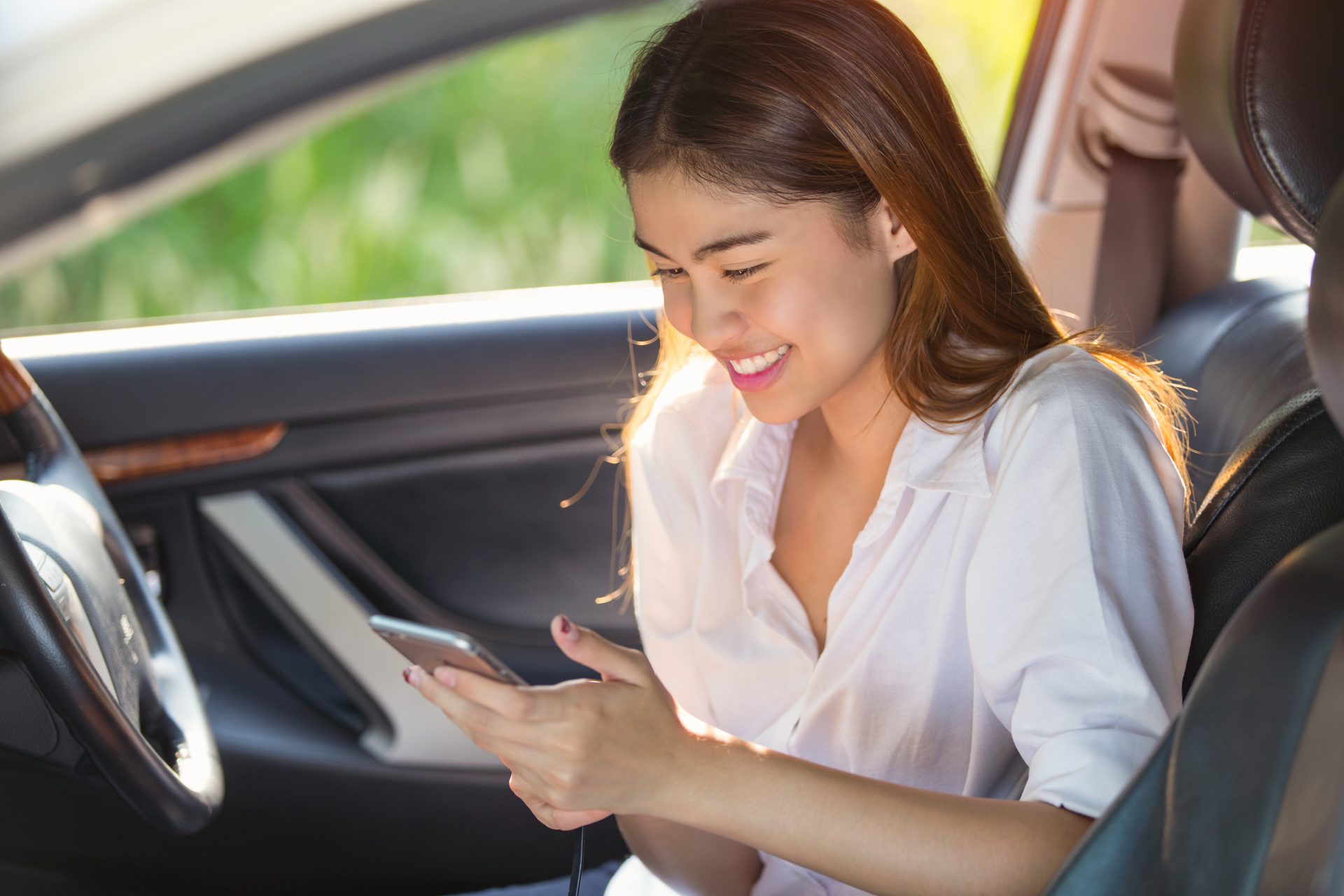 2116717-beautiful-asian-woman-smiling-while-sitting-car